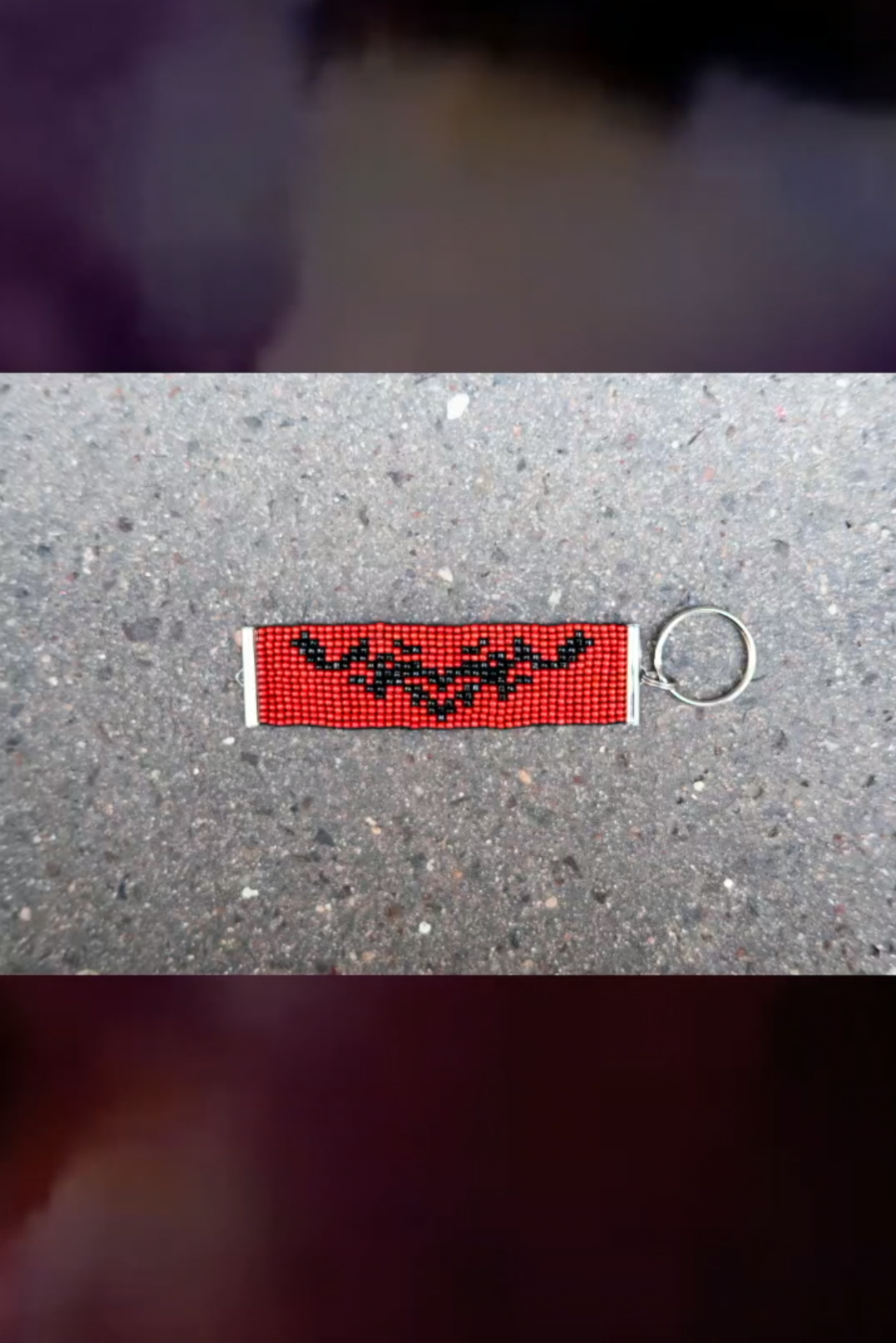 Red beaded keyring with a black bat motif
