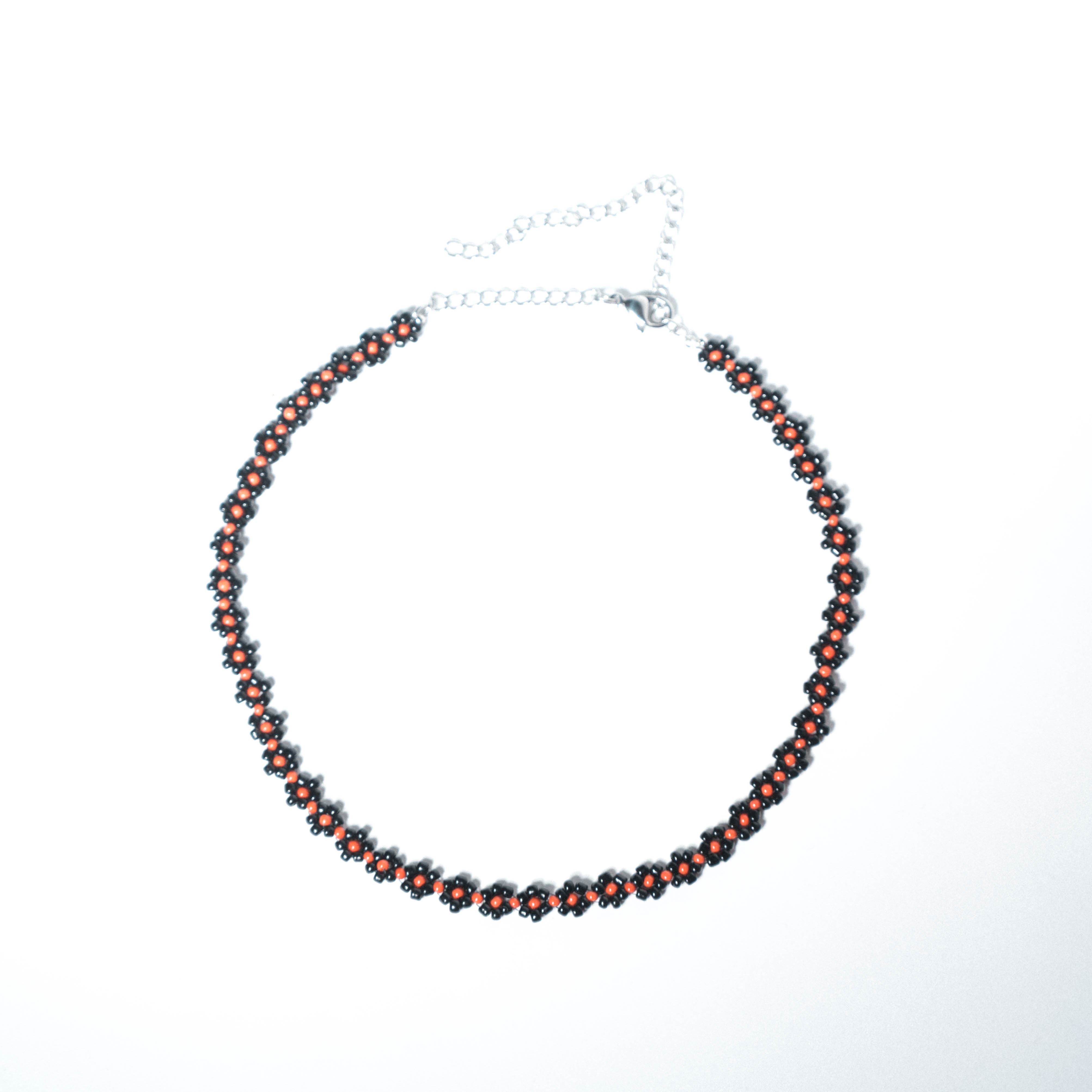 Black spiral-woven beaded necklace with a line of red beads