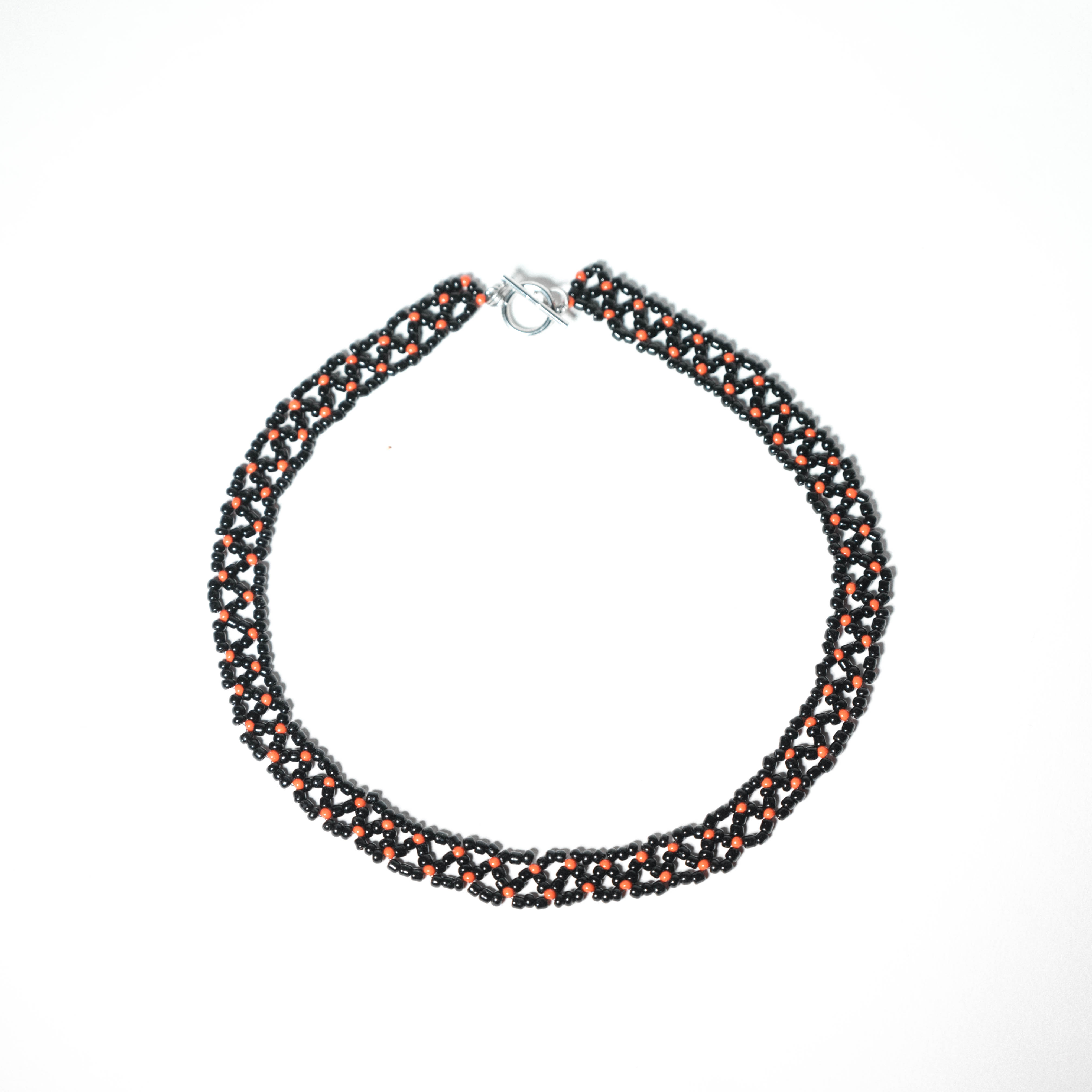 Wide woven black beaded necklace with red bead details